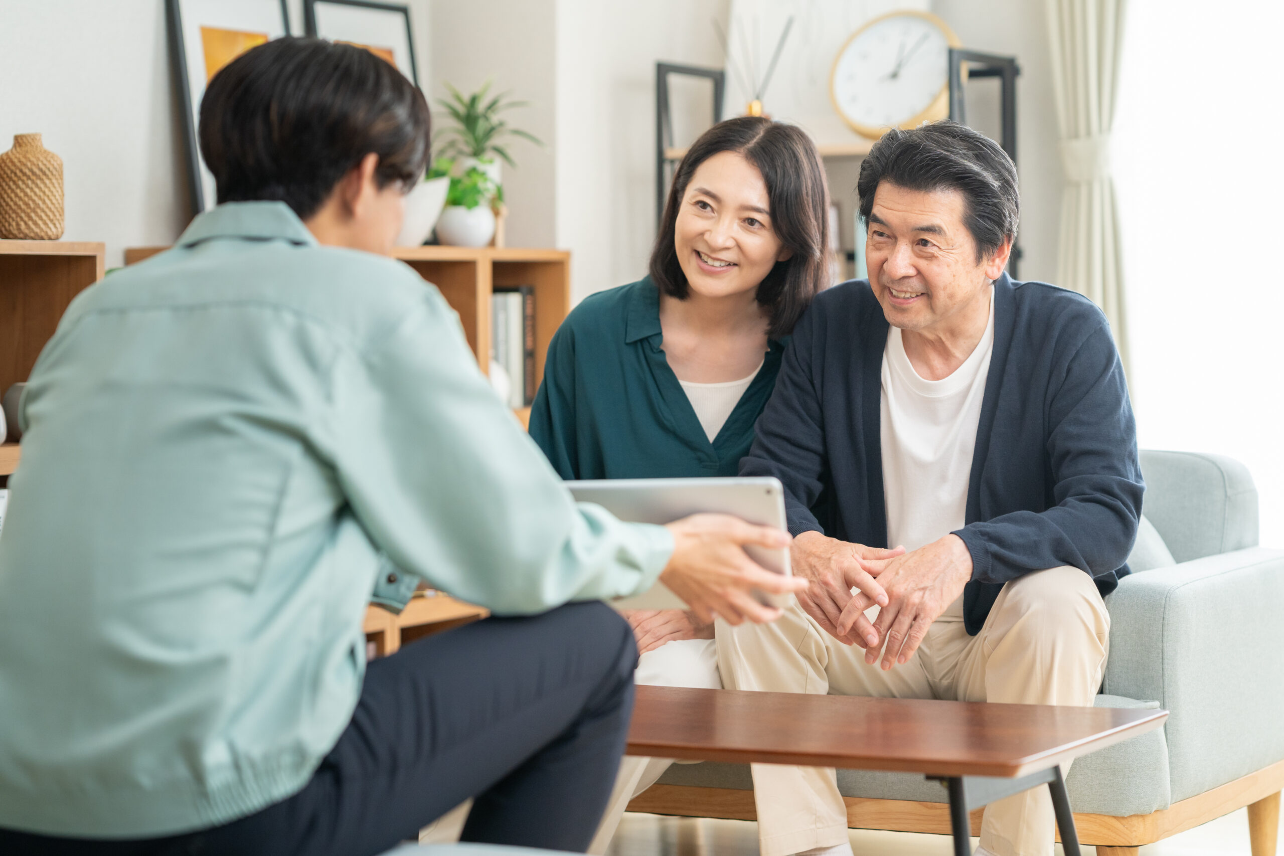 テーブルで間取りを広げて相談する打ち合わせの場面