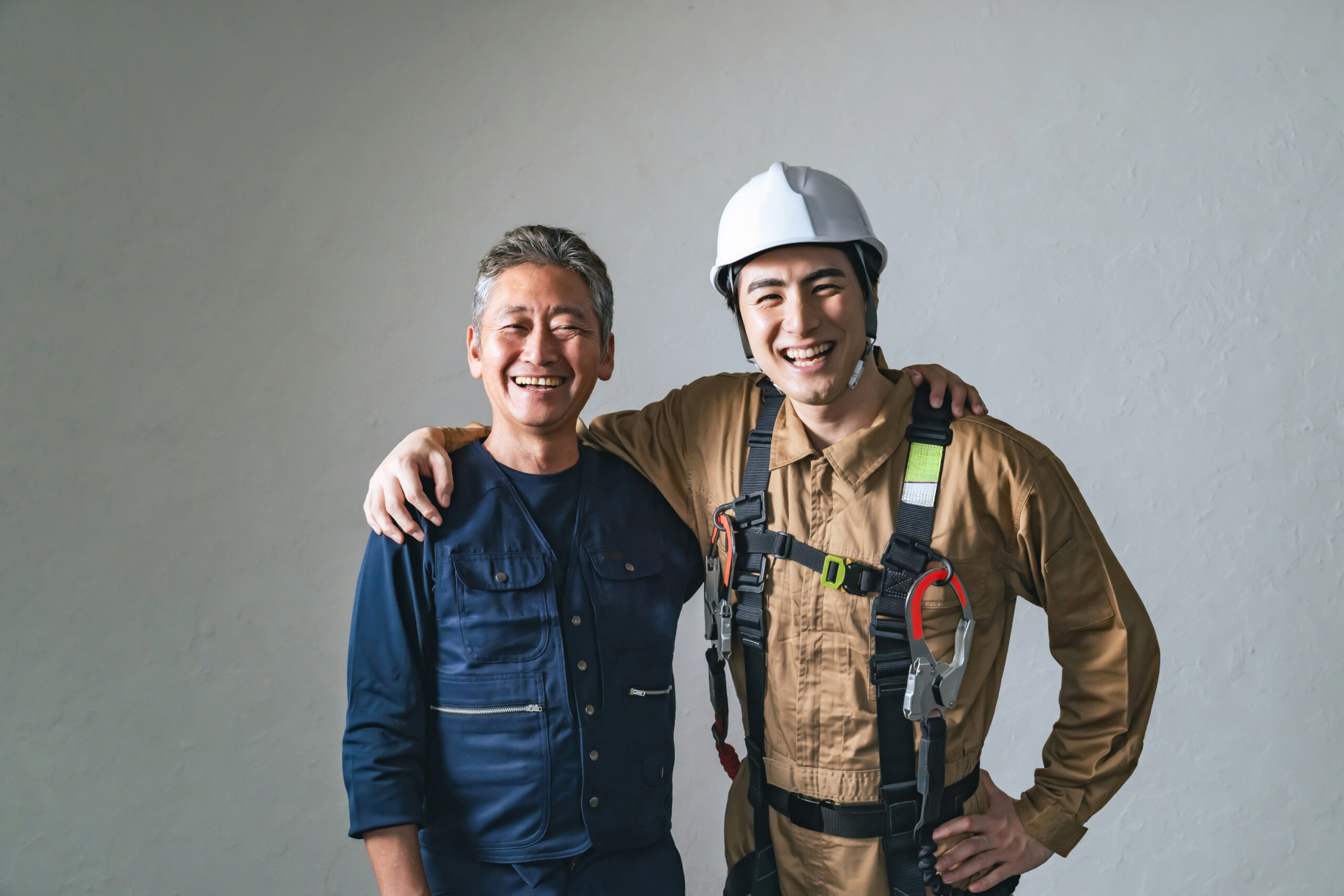 棟梁と若手の大工が並んで笑う（イメージ）