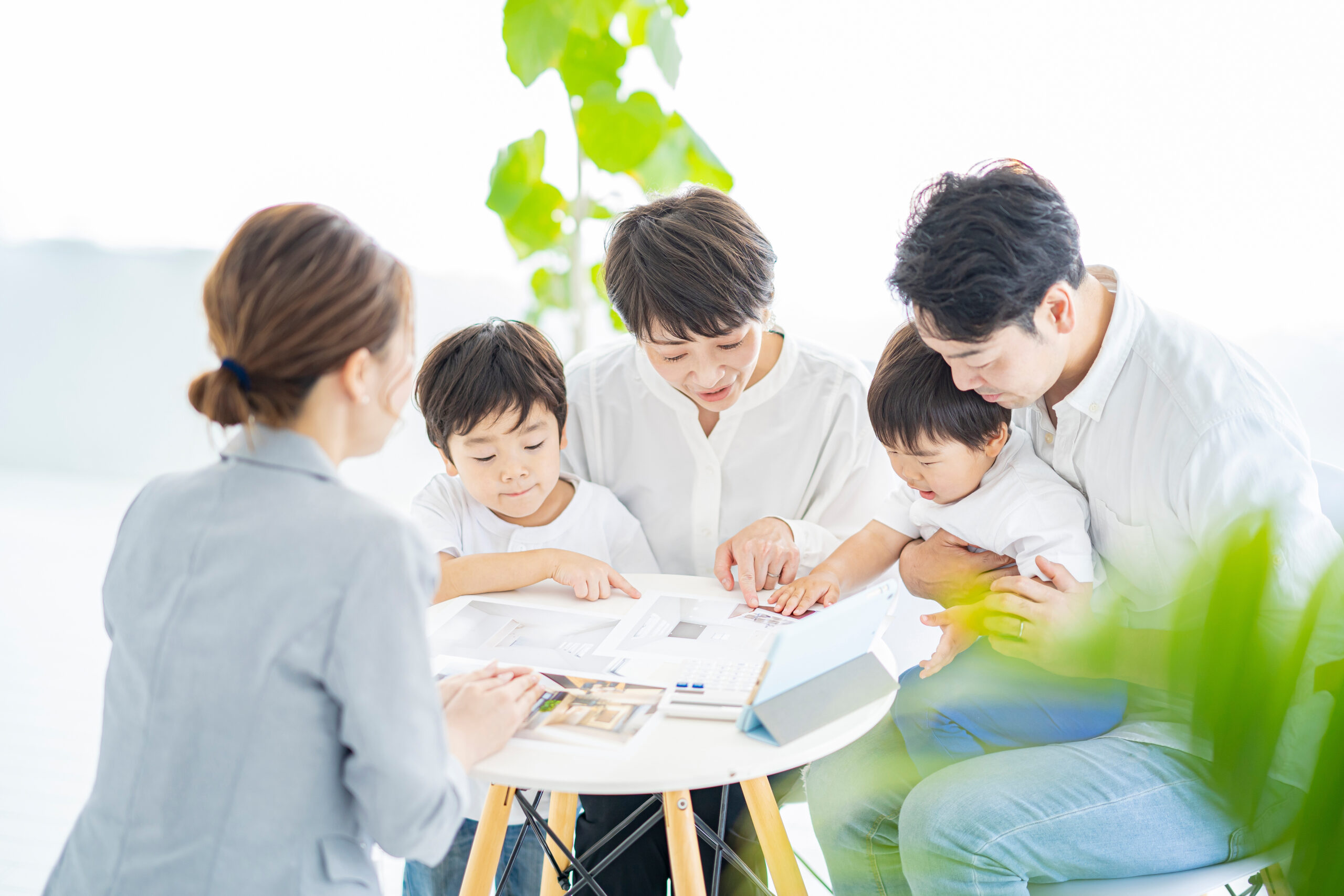ご家族と担当者がテーブルを囲み、資料を見ながら今の暮らしについて話している（デモ）